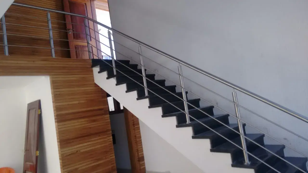Guarda-corpo em aço inox com travas horizontais acompanhando escada residencial